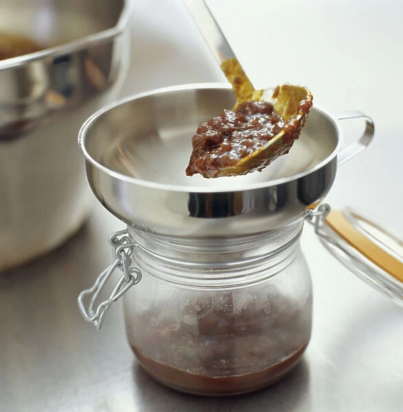 Using ladle to pour chutney into preserving jar, close-up