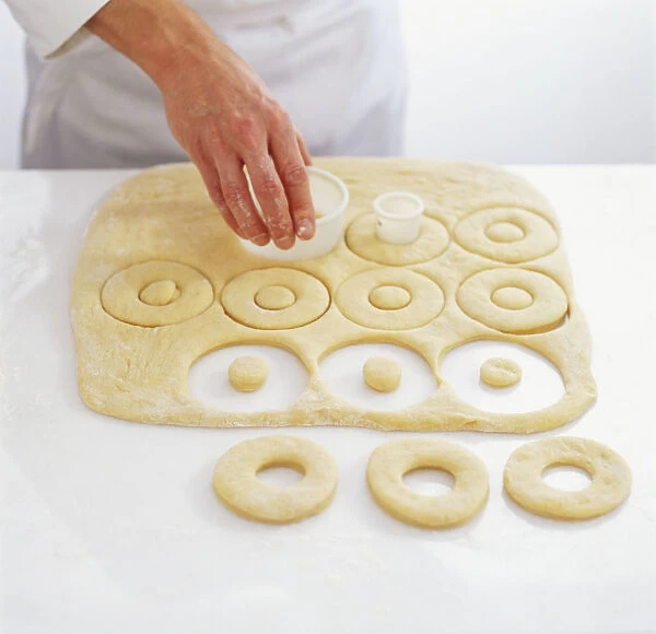 Using a pastry cutter to cut out circles to make doughnut shapes