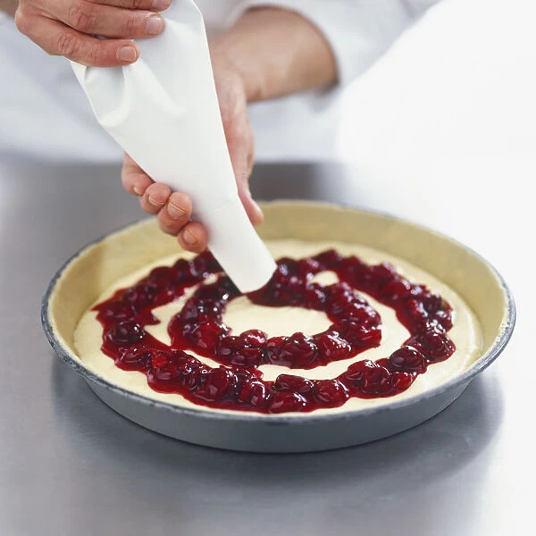 Using a piping bag to add cherries to dough in a baking dish