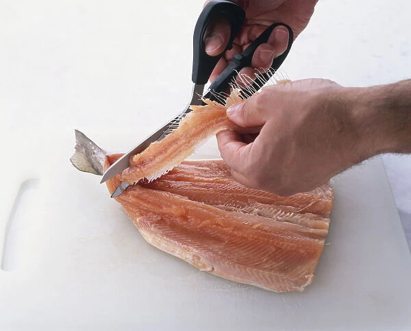 Using scissors to cut backbone from trout, know as butterflying, close-up