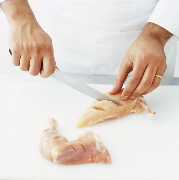 Using a sharp knife to make deep incisions to the bone of a chicken piece