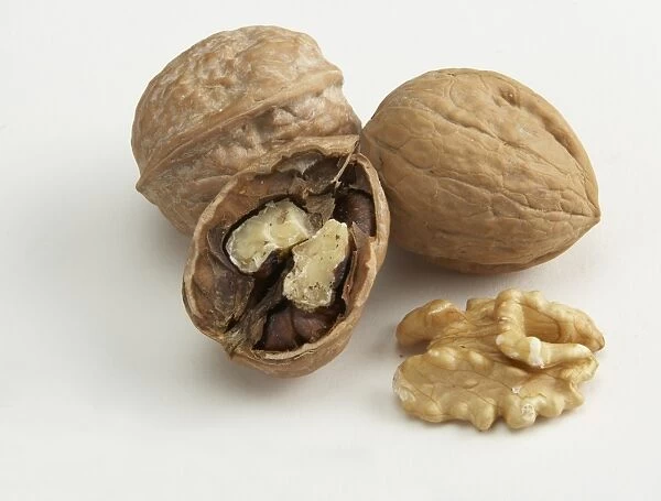 Walnuts and walnut shell against white background
