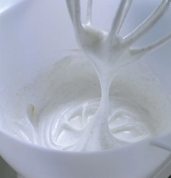 Whisked egg whites with vanilla in bowl