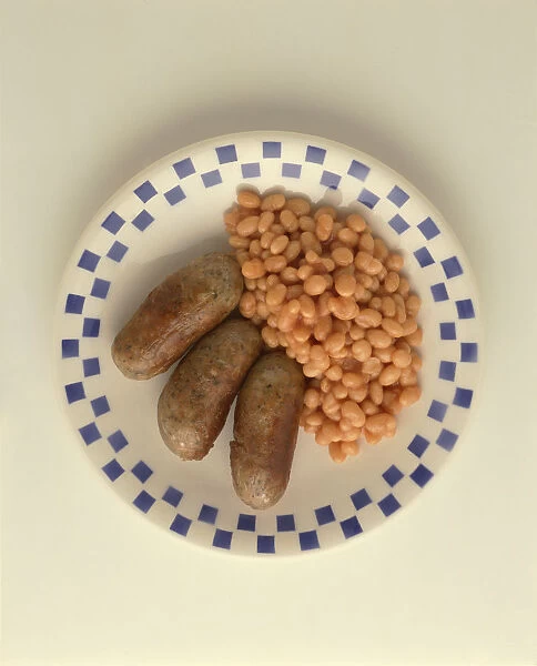 White and blue squared plate with 3 sausages and some baked beans
