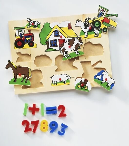 Wooden board with holes fitting shapes of farm animals, house and tractor, numbers from one to ten underneath