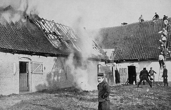 World War I 1914-1918: Fighting a fire on a farm in Artois, France, set alight by German shellfire