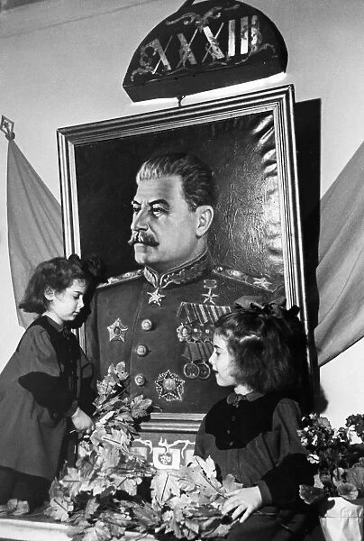 Two young girls at a kindergarten in the sverdlov district of moscow adorning a portrait of joseph stalin with greenery on the eve of the 33rd anniversary of the great october socialist revolution, november 7, 1950