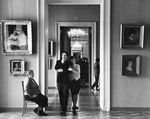 A young russian couple walk through the halls of a moscow museum, art gallery, ussr, 1960s