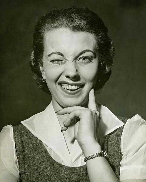 Woman winking in studio, (B&W), portrait