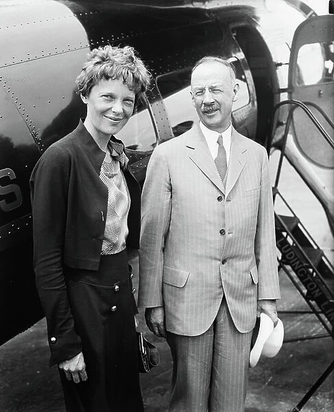 Amelia Earhart (L), Portrait with Man in front of Airplane, 1932 (b / w photo)
