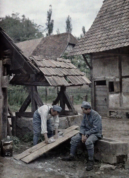 Two French soldiers are taking care of their laundry using boards set up on the trough of
