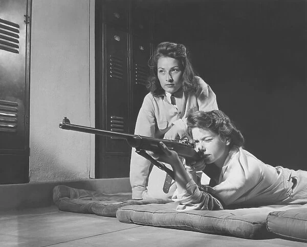 Girls practice marksmanship in high school hall. circa 1942