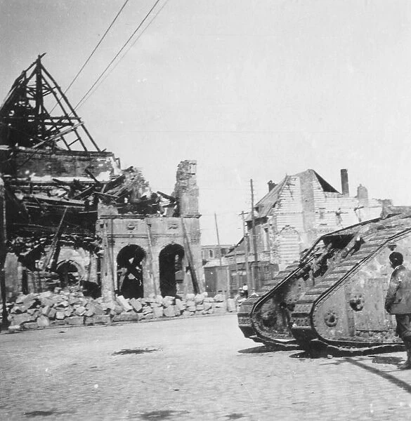 British tank in front of ruined buildings, Peronne, France, World War I, c1916-c1918. Artist: Nightingale & Co
