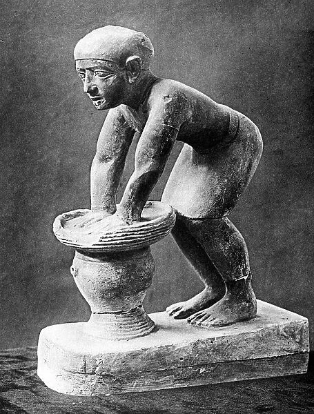 Figure of an Ancient Egyptian brewer pressing out fermented bread in a basket, c1910