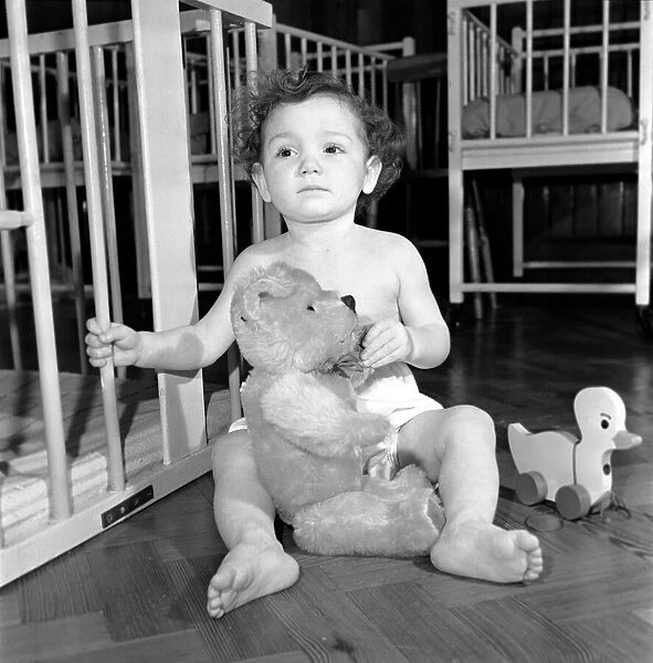 Child with teddy bear and toy top hat. December 1953 D7586-001