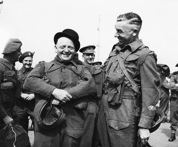 Colour Sergeant J. E. Pardoe (left) tries on a bowler hat in Gibraltar whilst waiting to