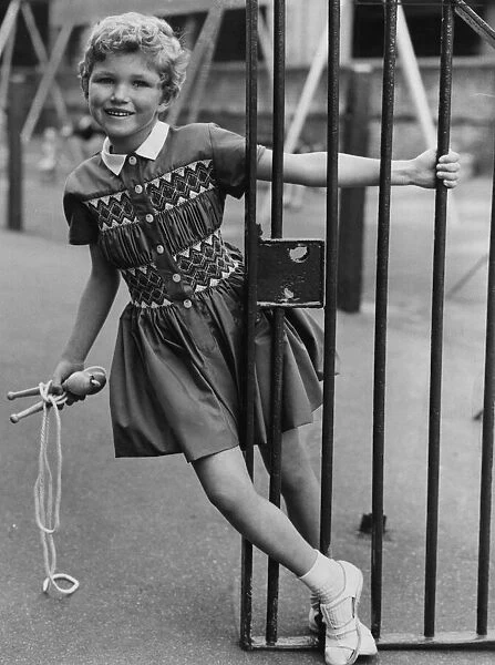 Girl seen here playing with skipping rope. She is wearing a dress which is similar to