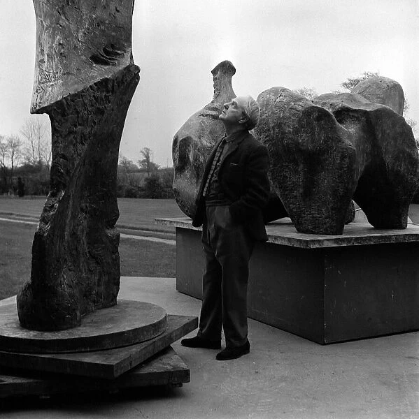 Henry Moore Artist and Sculptor outside his studio casting a critical over two-pieces of