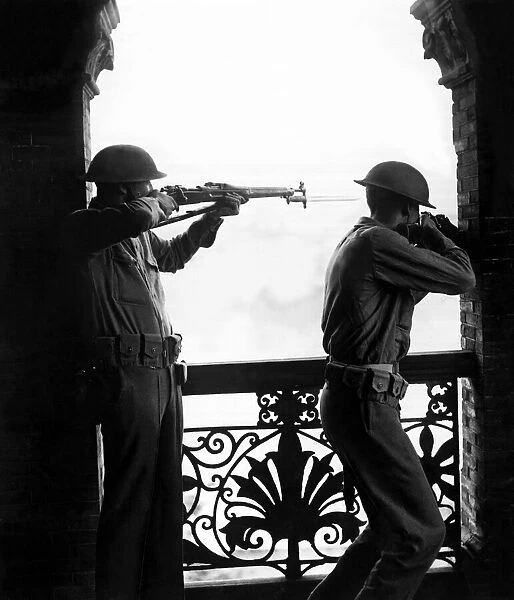 Soldiers of the Chinese defence force in Shanghai uniform with rifles take aim as they