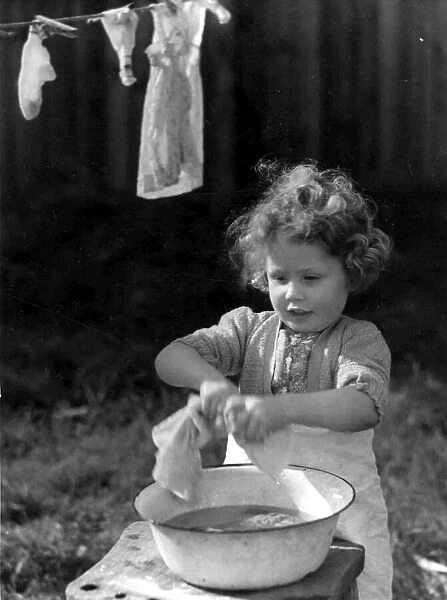 Young girl wringing out the washing. c. 1945 P044481