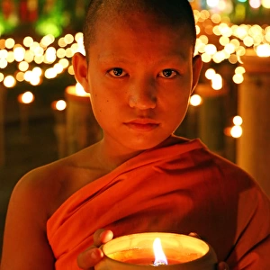 Buddhist Monk at Wat Phan Tao Temple holding candle