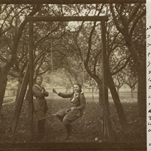 Two girl guides in uniform on a garden swing, Austria