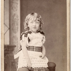 Little Victorian girl in lacy dress with tartan trimmings