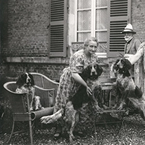 People with three dogs in a garden, France