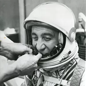 A technician adjusts the microphones for astronaut Virg?