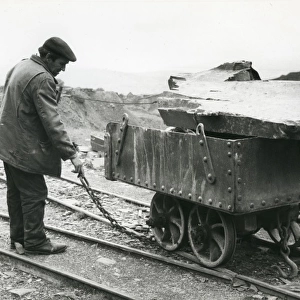 Workman with slate quarry tram, North Wales