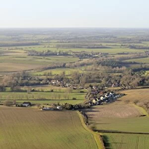 Aerial view of rolling rural landscape with small villages, winter wheat fields and pastureland, Suffolk, England, United Kingdom, Europe
