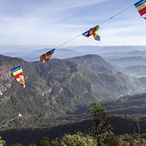 Buddhist flags framing the view down into the Dalhousie and the Hill Country beyond at sunrise from Adams Peak (Sri Pada), Sri Lanka, Asia