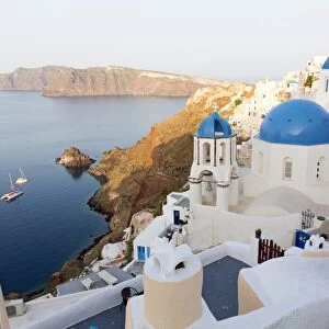 Classic view of the village of Oia with its blue domed churches and colourful houses
