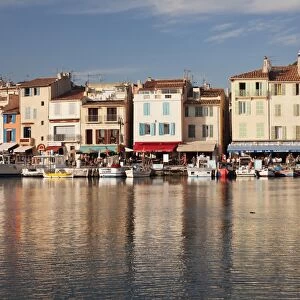 Fishing boats at the harbour, restaurants and street cafes on the promenade, Cassis