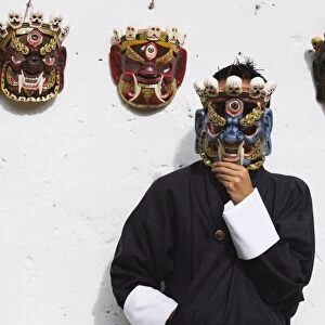 Man displaying traditional masks, Thimphu, Bhutan, Asia