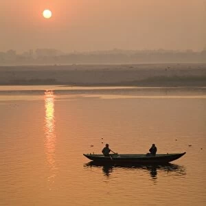 A photographer takes a photo from a rowing boat on the Ganga (Ganges) River at Varanasi