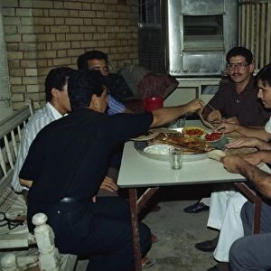 Portrait of a group of men friends enjoying meal of Mazgouf