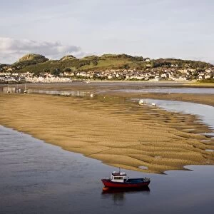 Red boat by exposed rippled sandbank on Conwy River