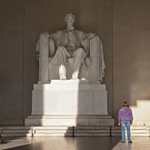 The statue of Lincoln in the Lincoln Memorial being admired by a young girl, Washington D. C. United States of America, North America