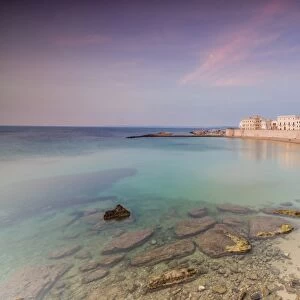 Turquoise sea frames the beach and the medieval old town at sunset Gallipoli, Province of Lecce
