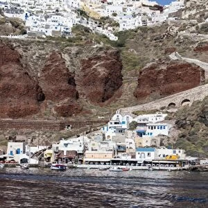 Typical Greek village perched on volcanic rock with white and blue houses and windmills