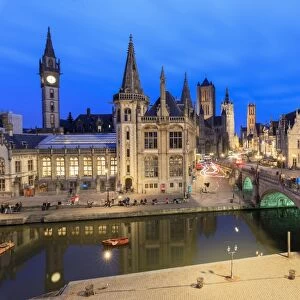 View of the historic area of Graslei and bell tower along Leie river at dusk, Ghent