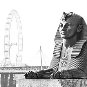 Bronze Egyptian sphinx statue on the Thames embankment, with The London Eye, Golden Jubilee Bridge and Big Ben in the background, London, England