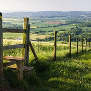 Footpath and style leading over fence through fields, Raddon Hill, Mid Devon, England