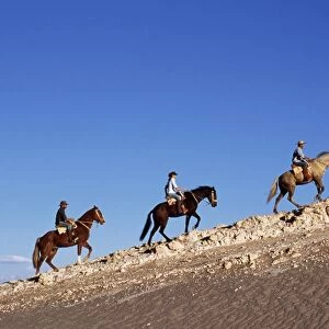 Horse riding along a ridge amongst the wind-eroded