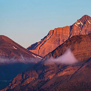 Rocky Mountains at sunrise with fog patches. Waterton Lakes National Park, Alberta, Canada