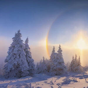 Solar halo in deep snow-covered winter landscape at Fichtelberg at sunset