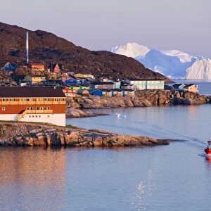 Colourful houses and hospital in Illulisat in the midnight sun on Greenland. Ilulissat is a UNESCO World Heritage Site because of the Jacobshavn Glacier or Sermeq Kujalleq which is the largest glacier outside Antarctica. The glacier drains 7% of