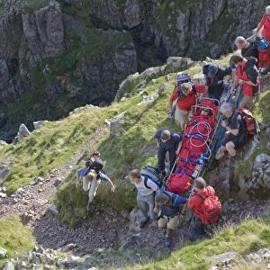 Members of Langdale Ambleside Mountain Rescue Team carrying an injured walker from the fells in Langdale Cumbria