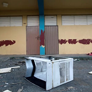 A broken air conditioner is seen outside a shut-down elementary school, in Toa Baja